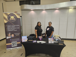 The TreSure fundraising event planner team standing behind a table with a black table cloth